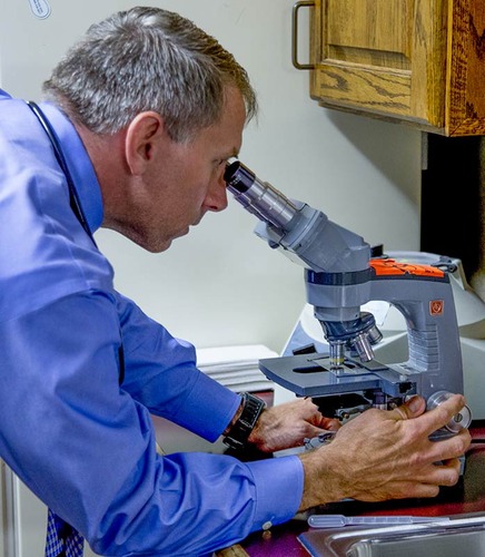 Doctor looking through microscope